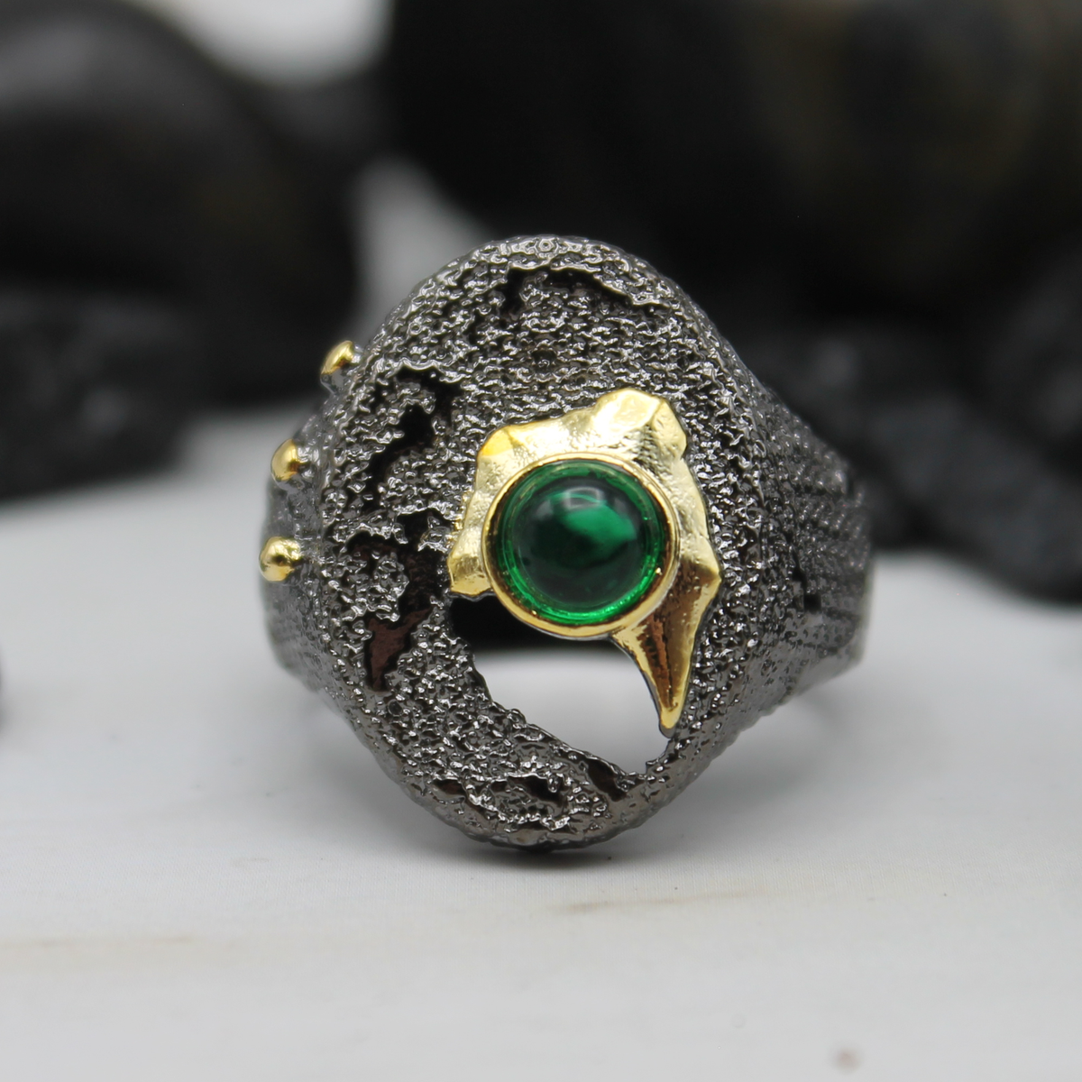 Zwart-gouden ring met groene ingelegde siersteen