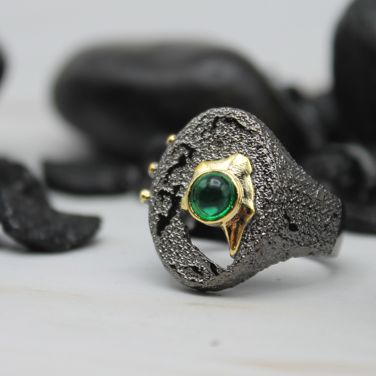 Zwart-gouden ring met groene ingelegde siersteen