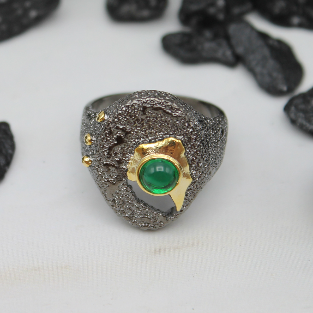 Zwart-gouden ring met groene ingelegde siersteen