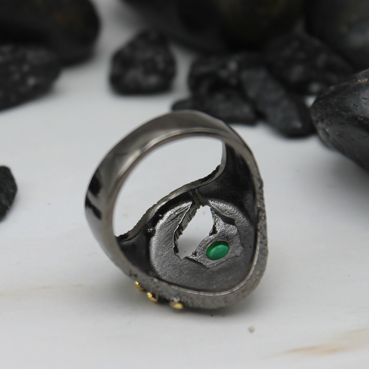 Zwart-gouden ring met groene ingelegde siersteen