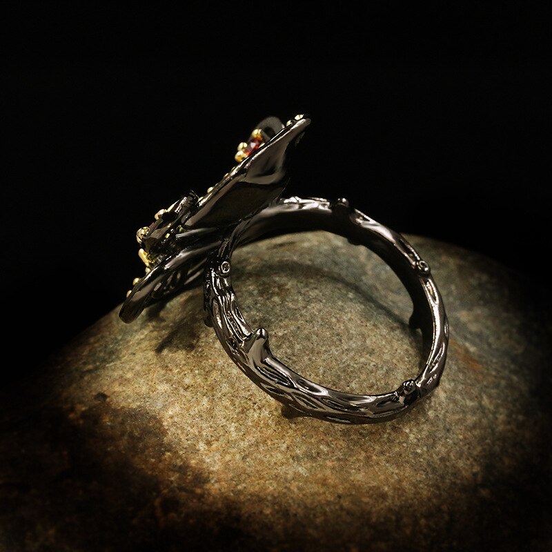 Bloemvormige ring met rood en groene sierstenen