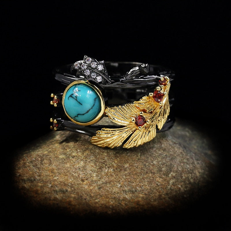 Gouden veder ring met blauwe siersteen