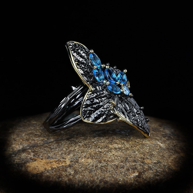 Bloemvormige ring met blauwe sierstenen