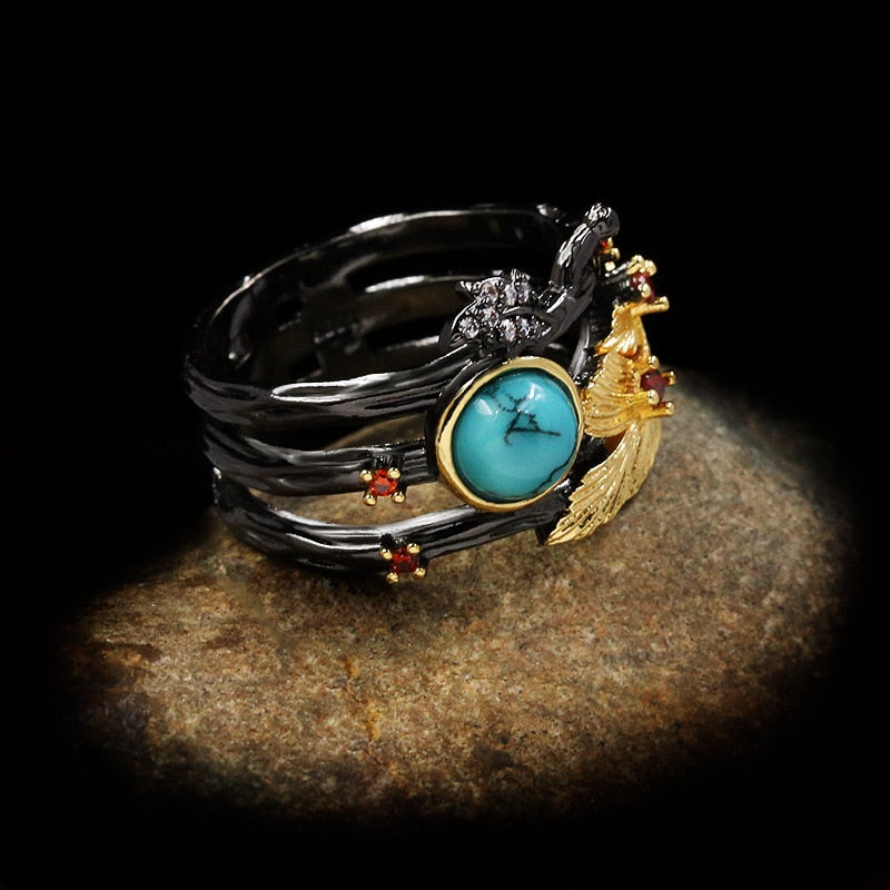 Gouden veder ring met blauwe siersteen