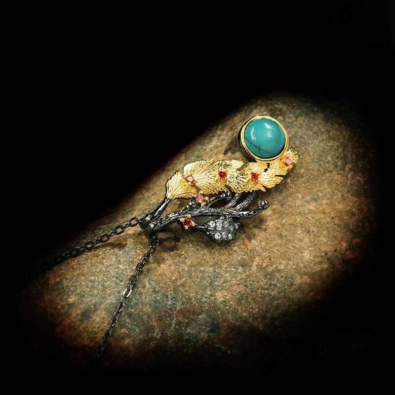 Gouden veder halsketting met blauwe siersteen