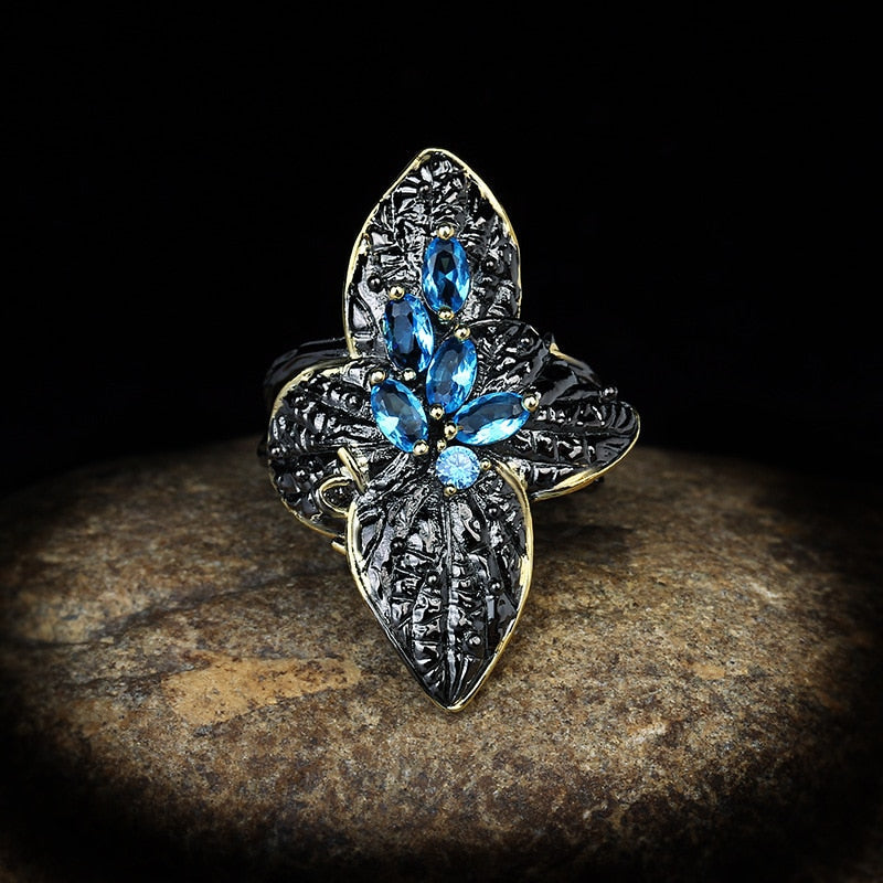 Bloemvormige ring met blauwe sierstenen