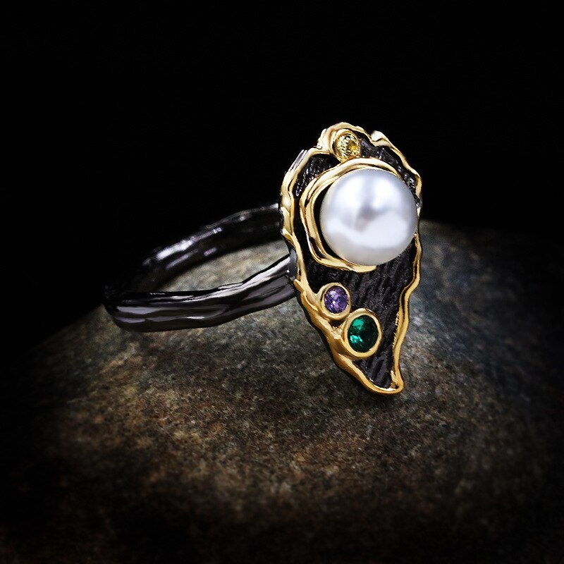 Bladvormige zwart-gouden ring met grote parel