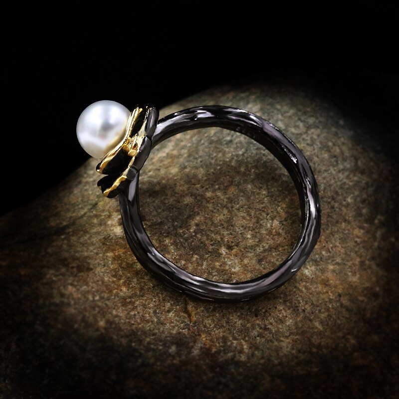 Bladvormige zwart-gouden ring met grote parel