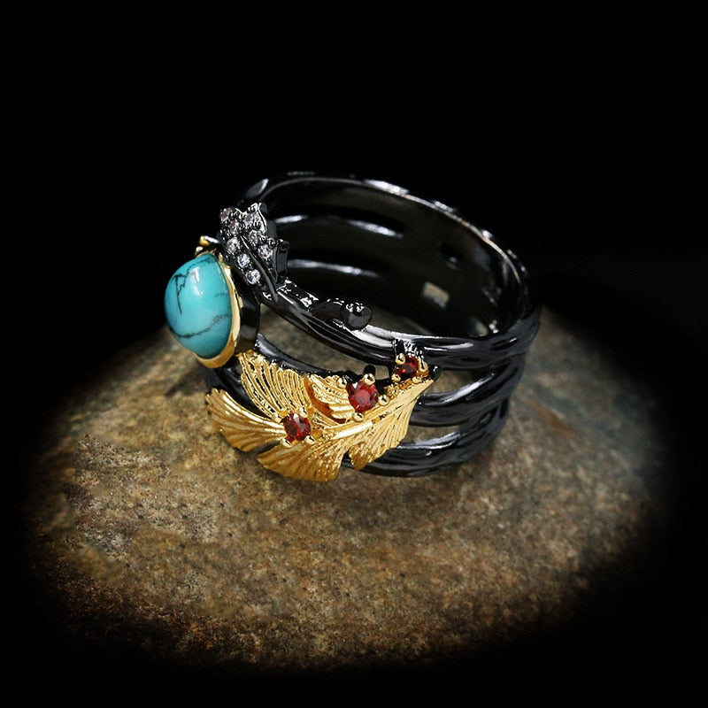 Gouden veder ring met blauwe siersteen