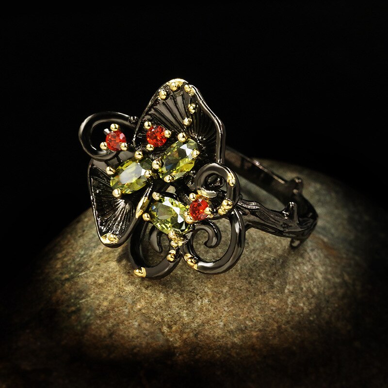 Bloemvormige ring met rood en groene sierstenen