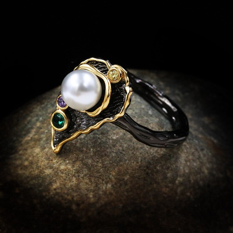 Bladvormige zwart-gouden ring met grote parel