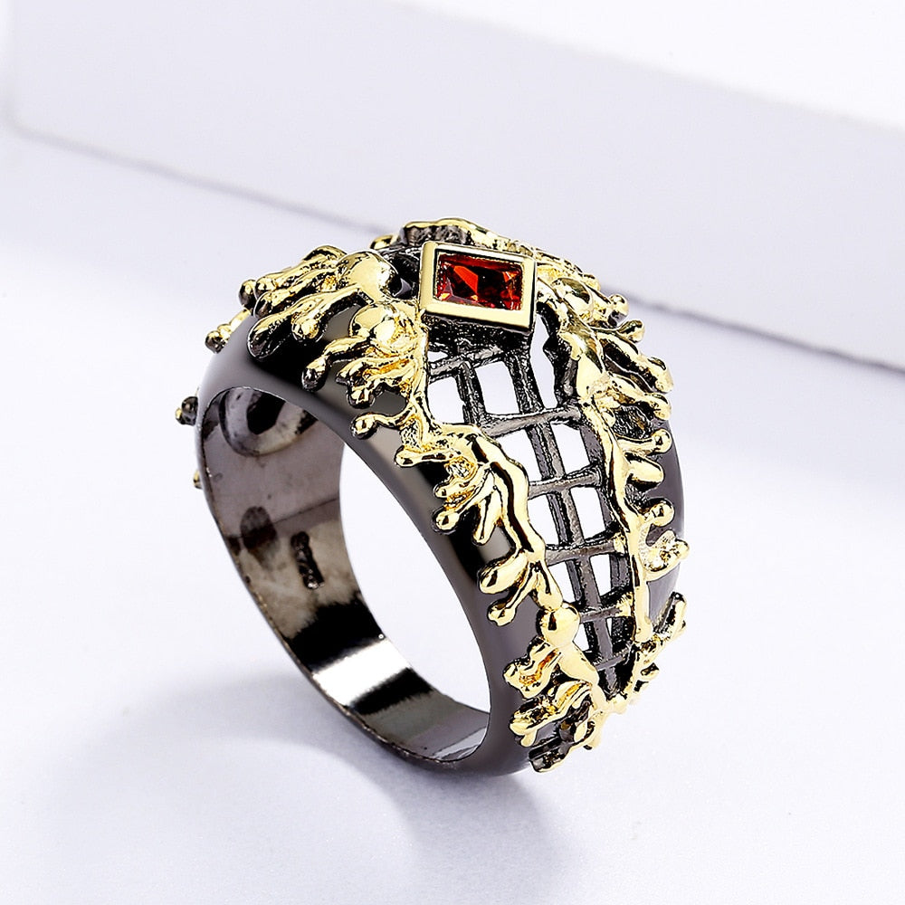 Gewoven zwart-gouden ring met rode siersteen
