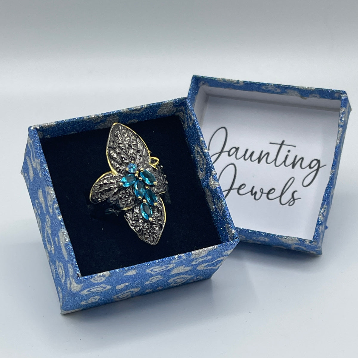 Bloemvormige ring met blauwe sierstenen