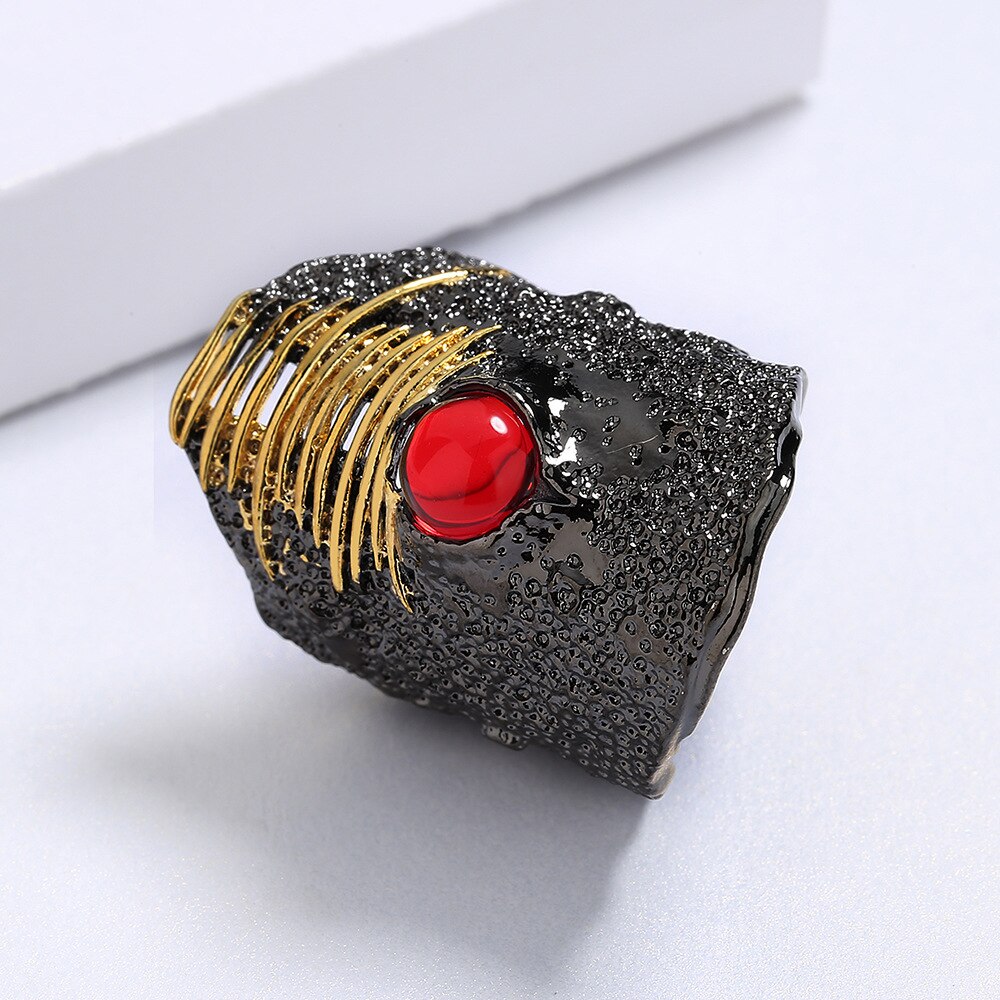 Afgeronde zwart-gouden ring met rode siersteen