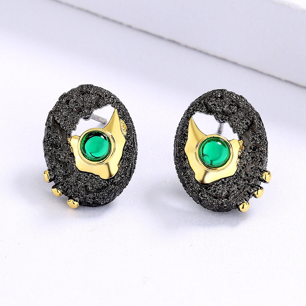 Gold hollow earrings inlaid with a green gem