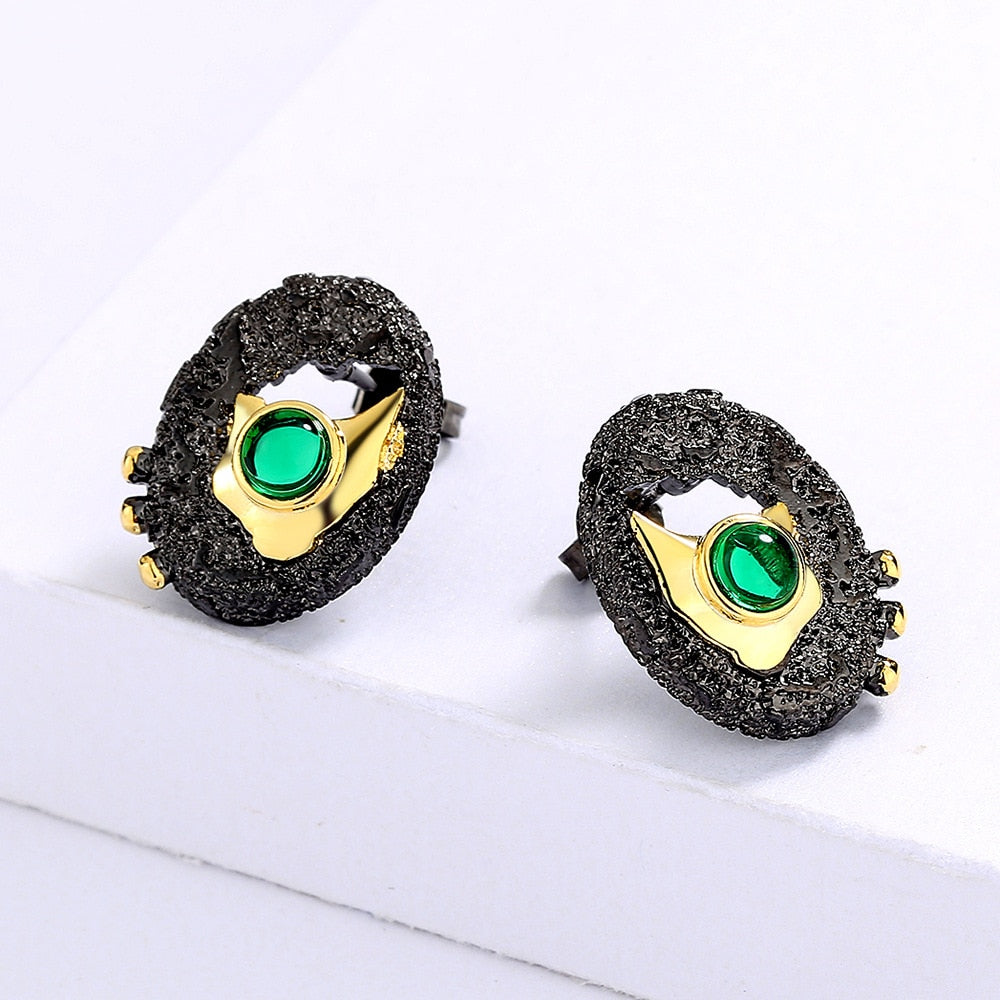 Gold hollow earrings inlaid with a green gem