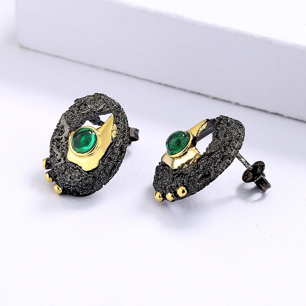Gold hollow earrings inlaid with a green gem